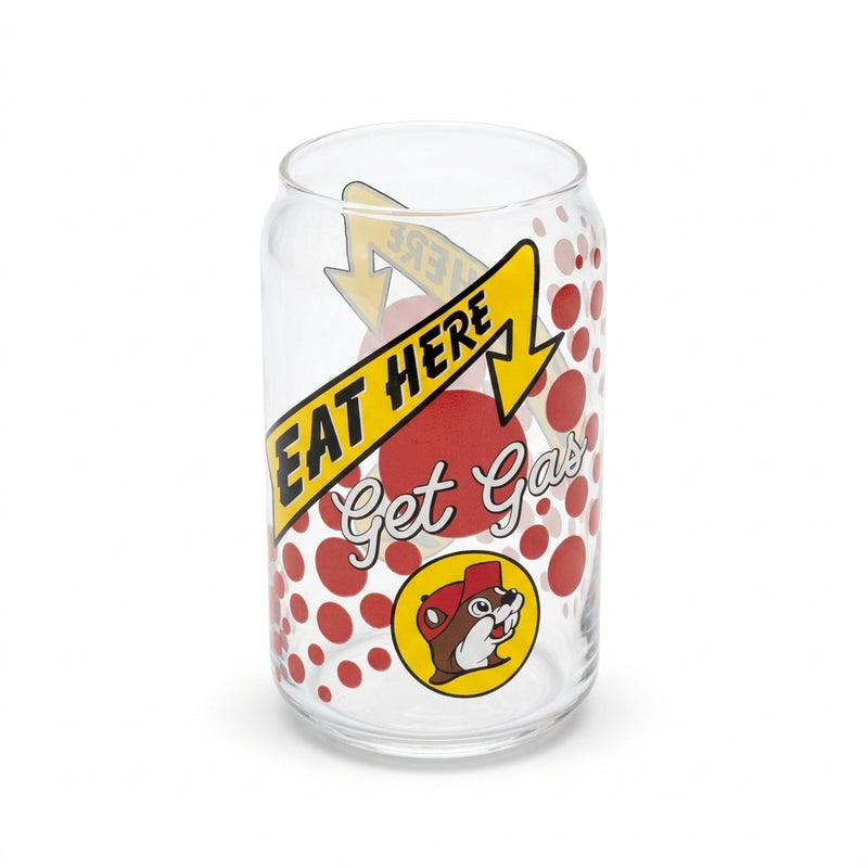 A clear 12oz can-shaped drinking glass featuring a yellow arrow reading "EAT HERE", white cursive script reading "Get Gas", red polka dots, and the yellow Buc-ee's beaver logo.