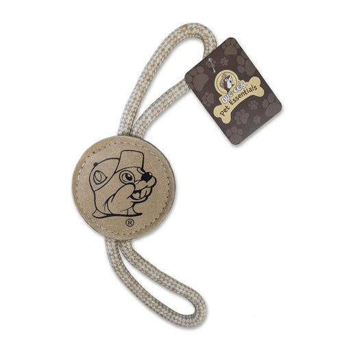 A Buc-ee's Pet Essentials dog toy with a round tan leather disc stamped with the Buc-ee's beaver logo, threaded with a thick, off-white braided rope loop for tossing.