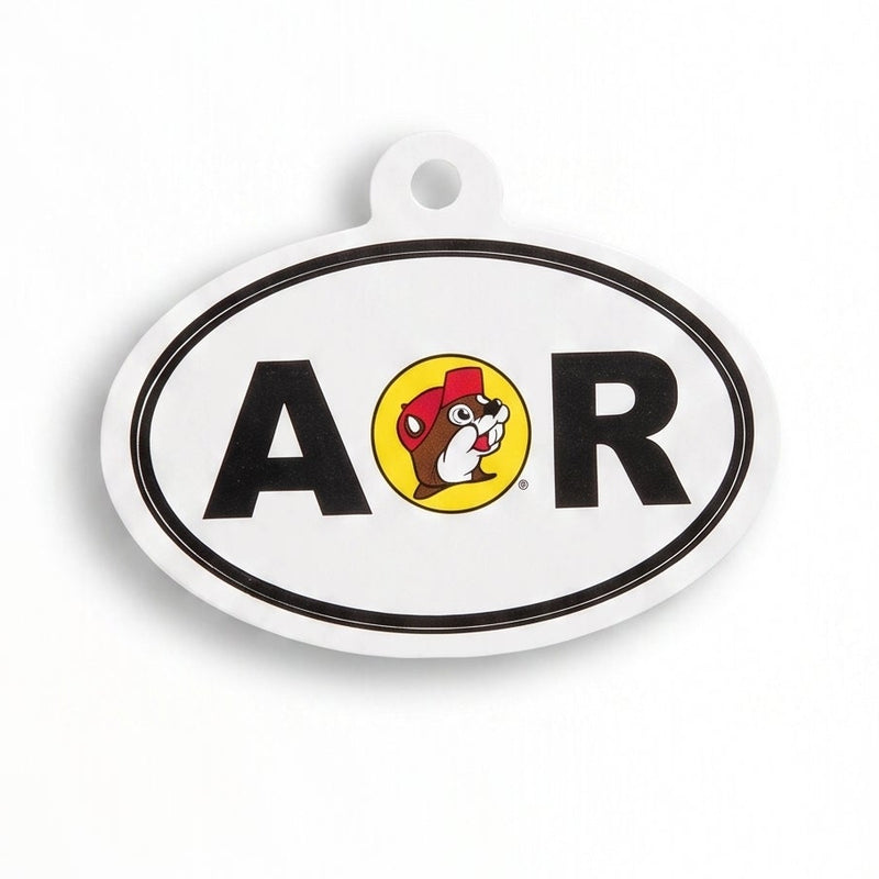 An oval-shaped white and black accessory charm featuring the letters 'A R' and a central cartoon dog logo, shown on a plain white background.