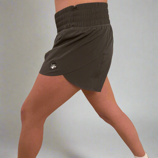 Side view of a woman in dark gray Buc-ee's performance shorts mid-stride