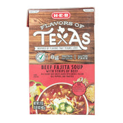 A front-facing view of a 17-ounce carton of H-E-B "Flavors of Texas" Beef Fajita Soup. The packaging features a rustic wood-grain background on the top half with the product title in bold white and red lettering. A prominent "Gluten Free" label and an "8g Protein per serving" callout are visible. The bottom half displays a vibrant serving suggestion of the soup in a bowl, loaded with strips of beef, green and yellow bell peppers, tomatoes, and topped with shredded cheese and jalapeños.