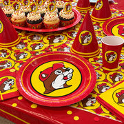 Party table with Buc-ee's lunch plates, cupcakes and party hats on a logo table cover