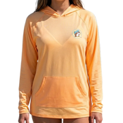 Person wearing an orange hoodie with a logo on a beach