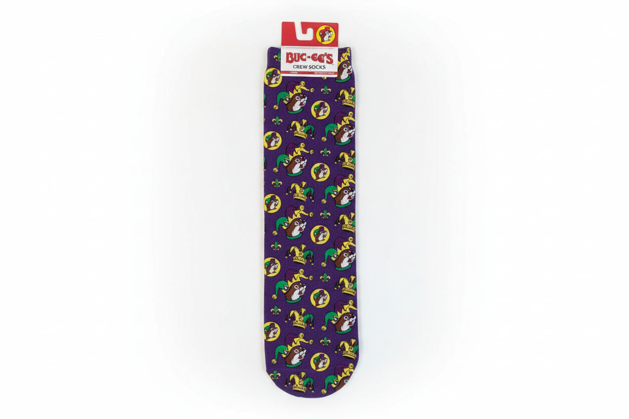 Purple Mardi Gras adult crew socks featuring repeating Buc-ee’s beaver mascot wearing jester hats, crowns, and masks in green, gold, and yellow, displayed flat with original Buc-ee’s tag attached.
