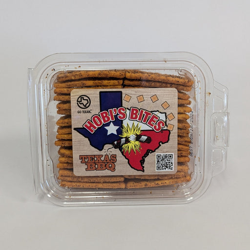 Hobi's Bites crackers with reddish seasoning in a clear container on a gray background