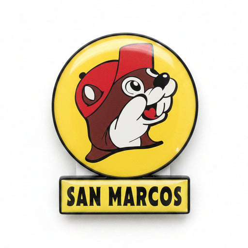 A San Marcos pin featuring a yellow circular emblem with a cartoon beaver wearing a red cap, above a yellow bar with the text 'SAN MARCOS' in black.