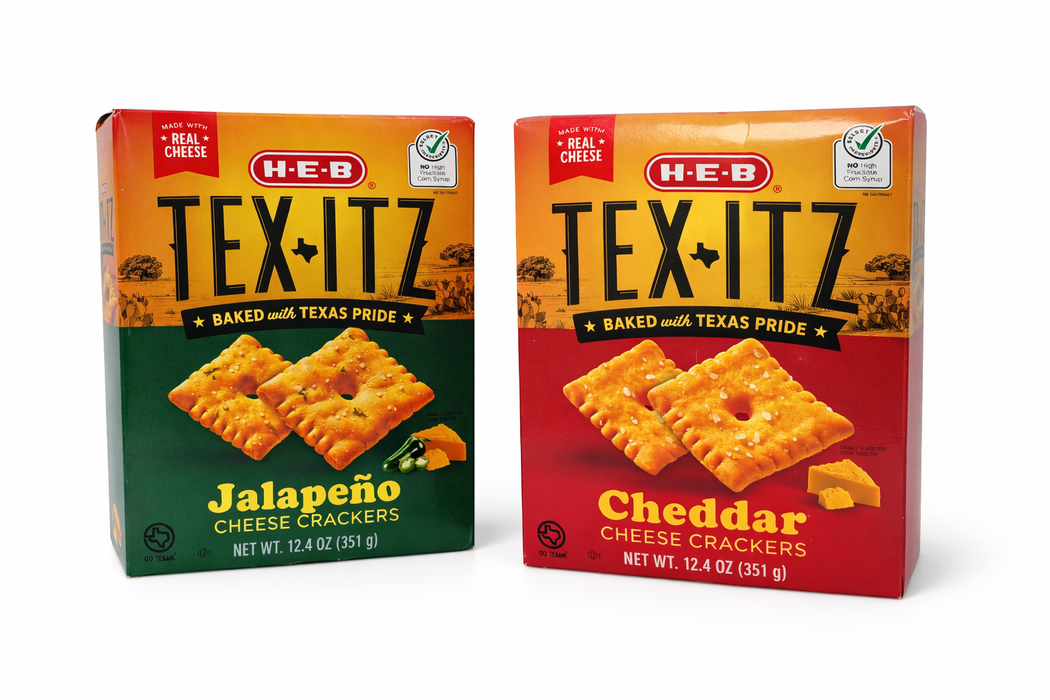 Two boxes of H-E-B TexitZ cheese crackers, one Jalapeño flavor in a green box and one Cheddar flavor in a red box, shown upright with cracker images on the front.