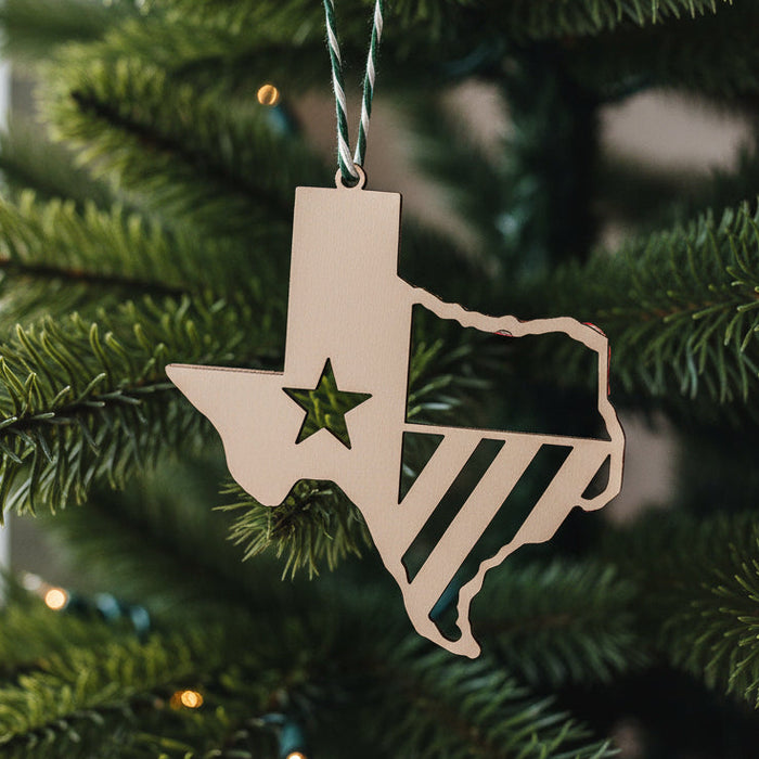 A handcrafted wooden ornament in the shape of the state of Texas with a star and flag detailing, attached with a green and red string.