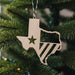 A handcrafted wooden ornament in the shape of the state of Texas with a star and flag detailing, attached with a green and red string.