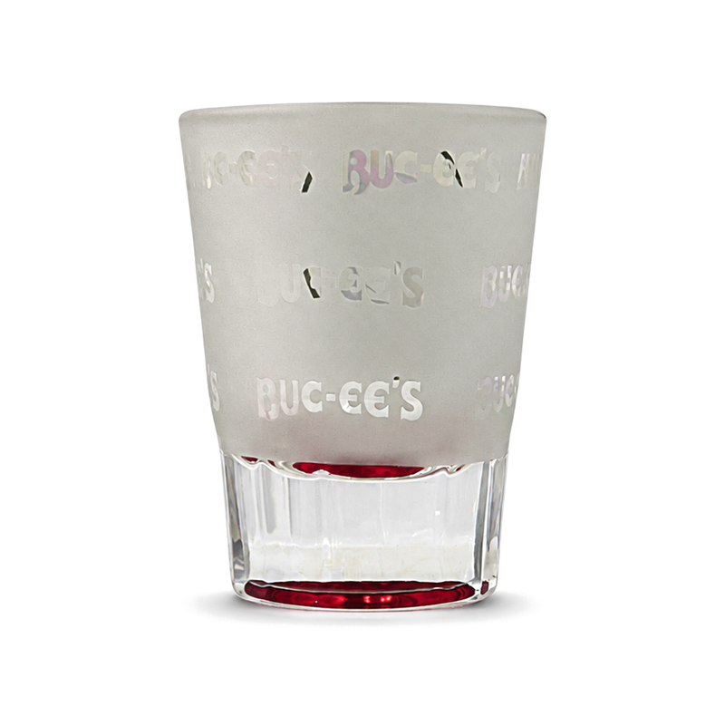 Buc-ee's New Braunfels frosted shot glass with a repeating logo pattern, clear faceted base and red-tinted bottom, a Texas road trip souvenir