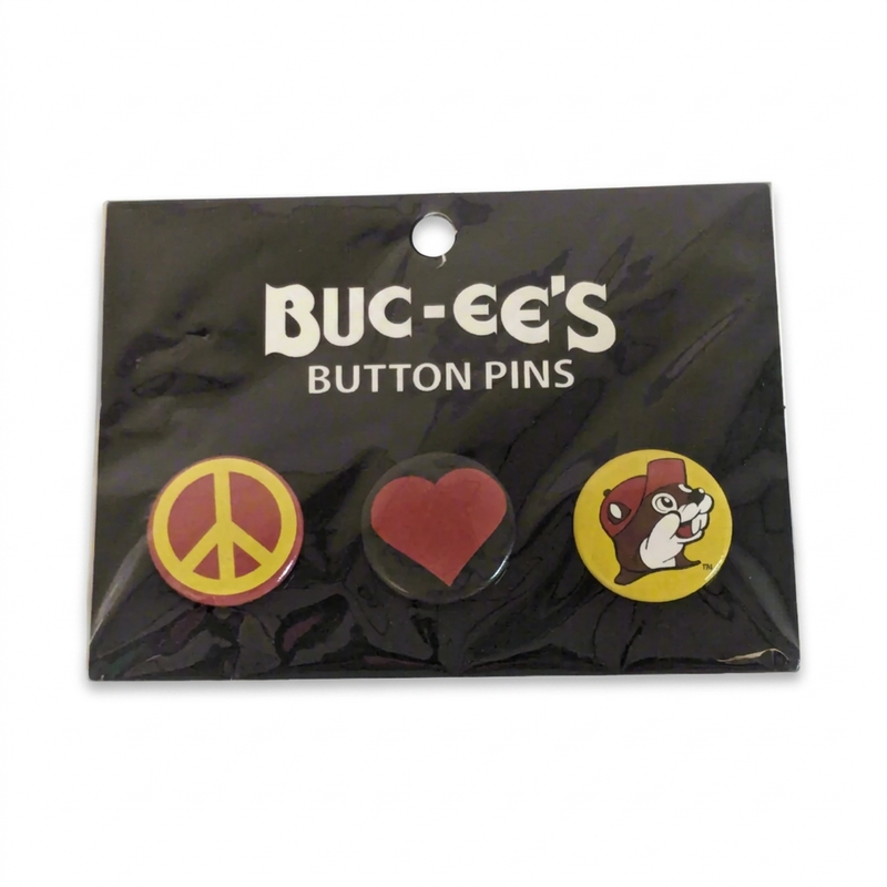 Buc-ee’s Button Pins 3-pack with a yellow and red peace sign, a red heart on black, and the beaver logo on a black card