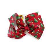 Large red grosgrain hair bow printed with Santa Buc-ee logos and decorated Christmas trees, centered with a red ribbon knot on a display card.