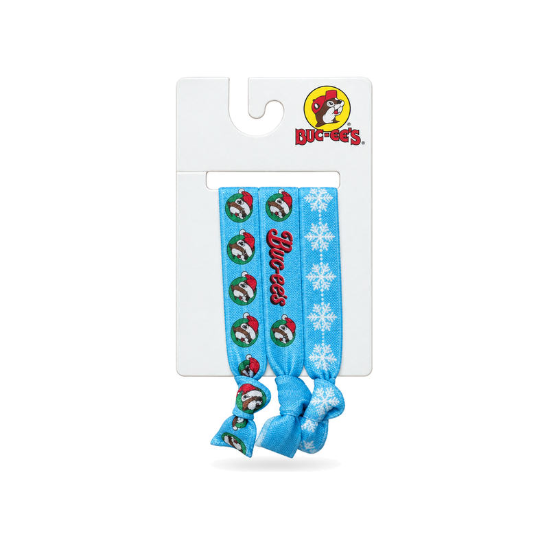 Buc-ee's Christmas hair ties 3-pack in blue with Santa hat beaver, script logo, and white snowflake prints on a display card