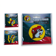 Three Buc-ee’s Chrome Emblem designs in packaging: a yellow Texas shape, a yellow LOVE design, and a large round beaver logo