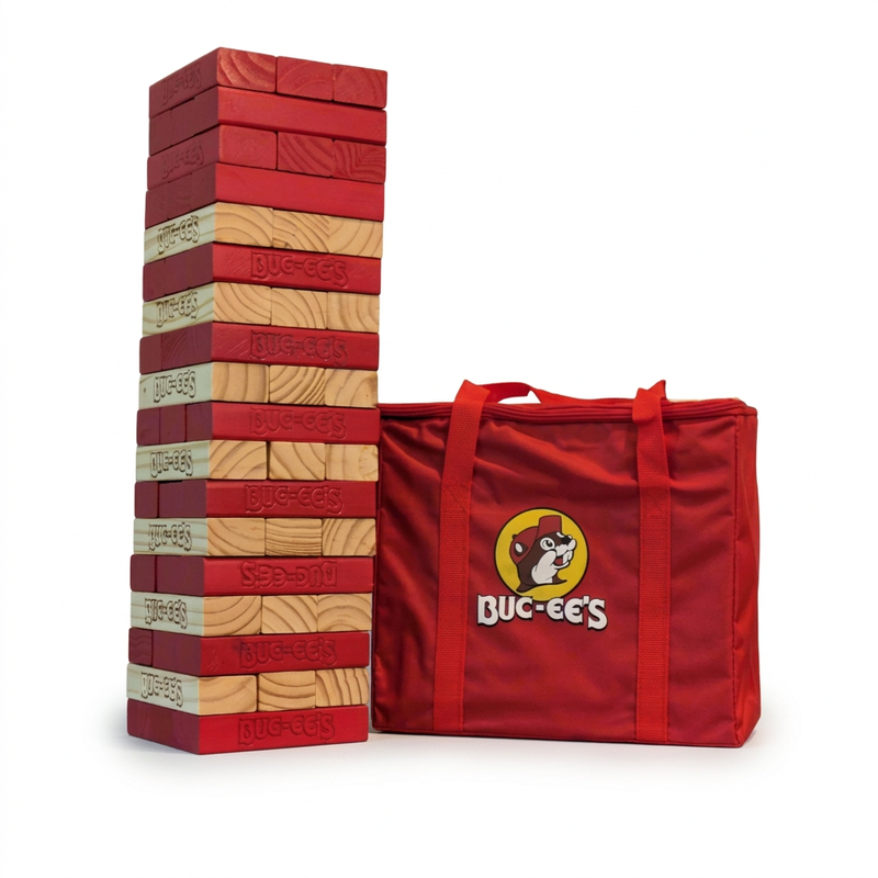 Buc-ee’s Jumbo Block Tower Game with stacked red and natural wood blocks stamped with the logo, beside a red carry bag