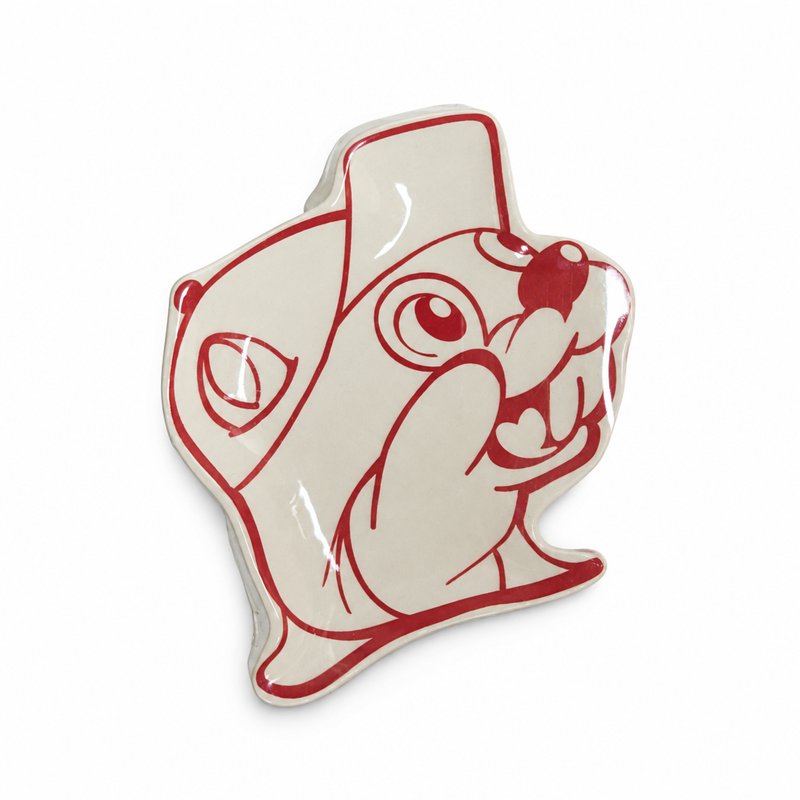 Buc-ee's Spoon Rest, a buc-ee-shaped ceramic dish in glossy cream with a red line-art Buc-ee beaver in a cap