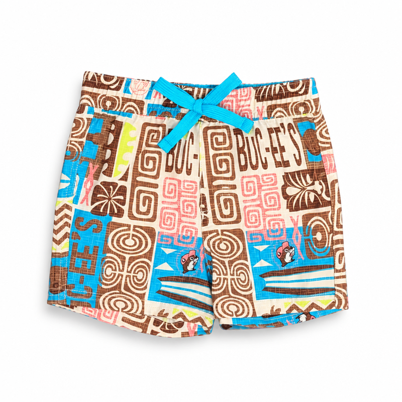Buc-ee’s toddler tiki swim trunks with turquoise bow drawstring and print of surfboards, spirals, and beaver logos