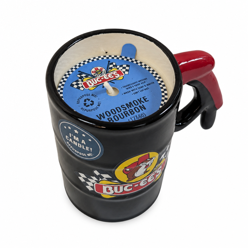 Top view of the Buc-ee's Woodsmoke Bourbon candle mug showing cream wax, a white wick, and a blue checkered-flag label