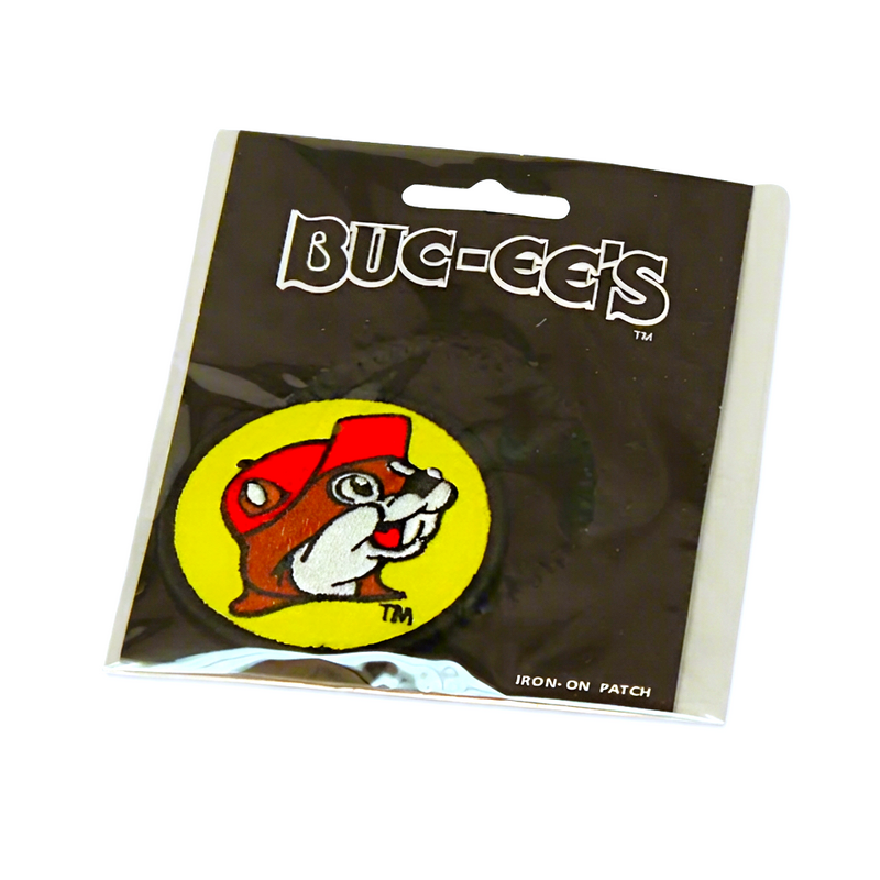 Buc-ee’s yellow logo iron-on patch, a round embroidered beaver in a red cap with black border, on a black retail card