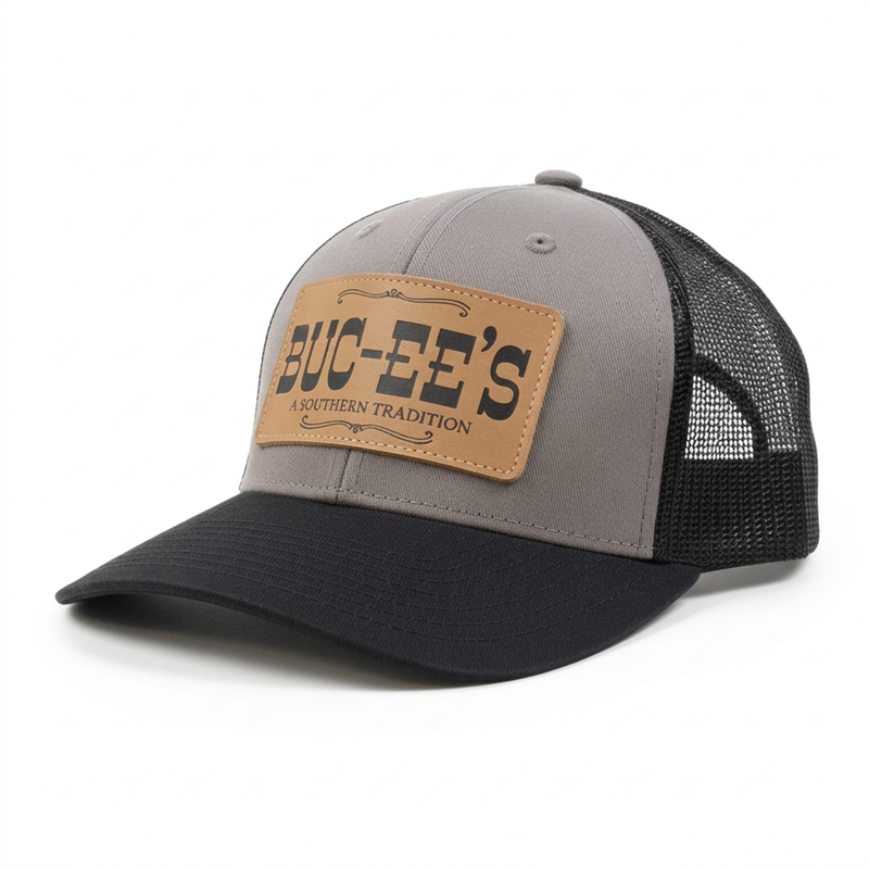 Buc-ee’s A Southern Tradition trucker hat in gray and black with a mesh back, curved brim, and tan leather-look patch