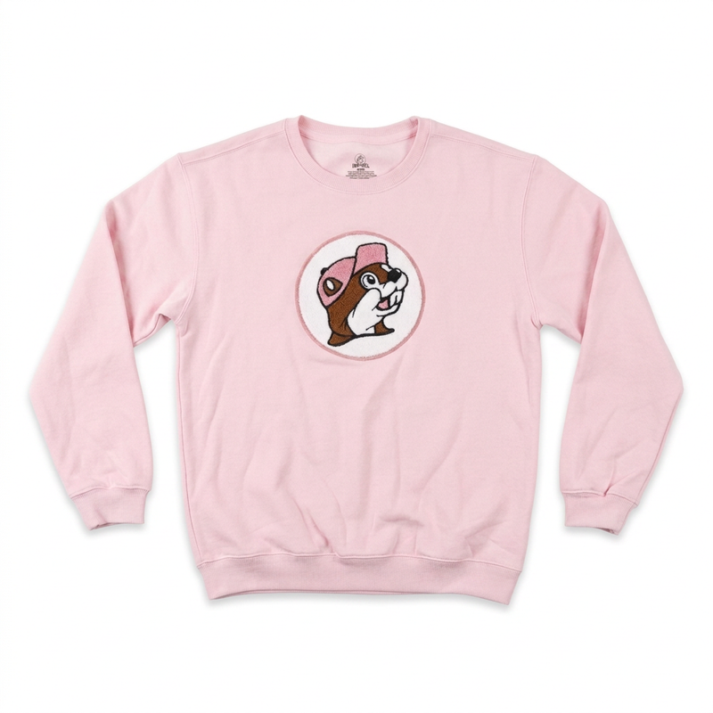 Buc-ee’s adult pink crewneck sweatshirt with a fuzzy chenille beaver logo patch in a white circle on the chest and ribbed cuffs