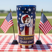 Yukon Outfitters tumbler with American flag design on a checkered tablecloth