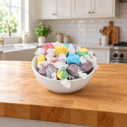 Buc-ee's Assorted Saltwater Taffy in a white serving bowl on a kitchen counter, with blue, yellow, green, and purple pieces