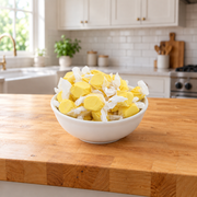Buc-ee's Banana Saltwater Taffy piled high in a white bowl on a butcher block kitchen counter, ready for sharing