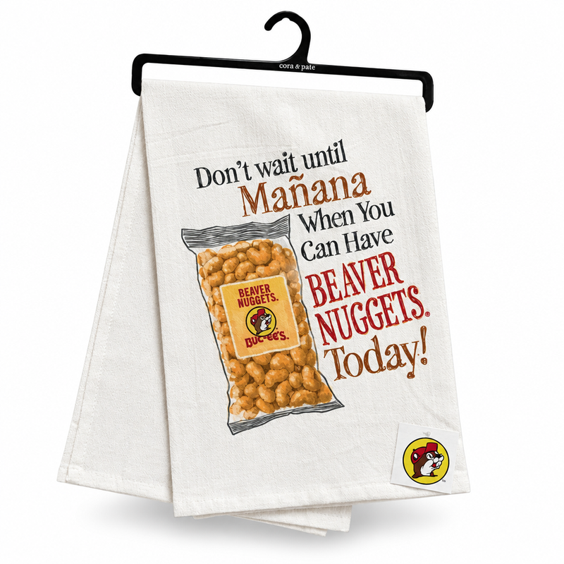 White tea towel on a hanger printed with a Beaver Nuggets bag and "Don't Wait Until Mañana" slogan