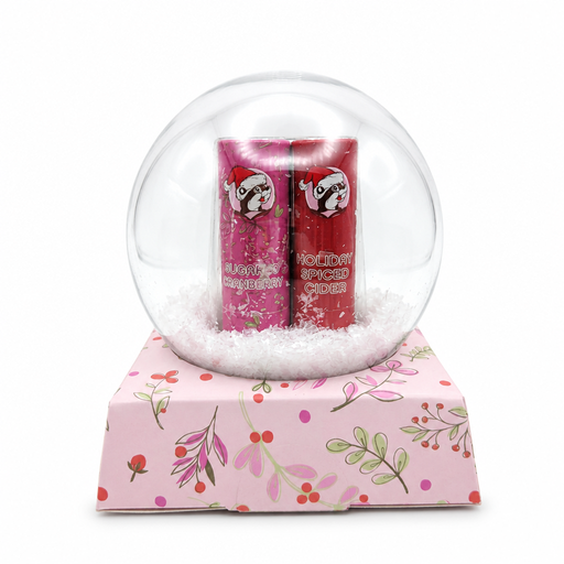 Buc-ee's snow globe lip balm gift set showing Sugared Cranberry and Holiday Spiced Cider lip balm tubes sitting in white faux snow.