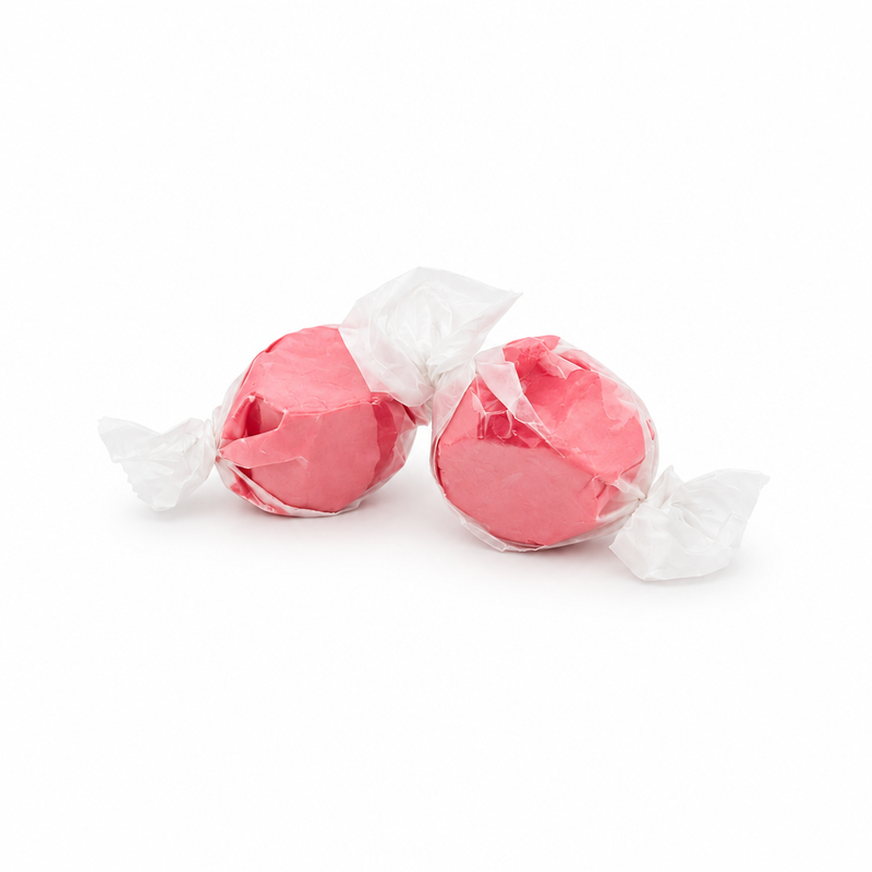 Buc-ee's Cinnamon Saltwater Taffy, two pink pieces in wax paper twist wrappers, from a 12 oz bag of Texas road trip candy