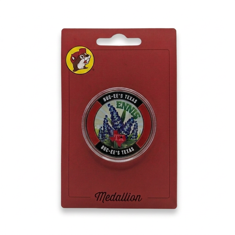 Buc-ee’s Ennis, Texas collectible medallion with bluebonnet design and red Texas map in a clear capsule on red card.
