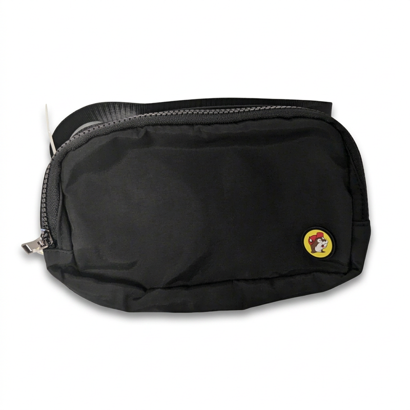 Buc-ee’s fanny pack in black with a zip top, silver zipper pull and round yellow beaver logo patch, strap folded behind