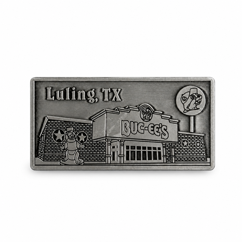 A rectangular antique pewter metal magnet with 3D relief detailing of the Buc-ee's Luling storefront. Features "Luling, TX" engraved in the upper left corner, the Buc-ee's store building with main entrance, the beaver mascot statue out front, and the tall roadside lollipop sign on the right.