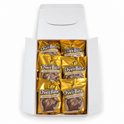 Top-down view of an open Buc-ee's OverBite Milk Chocolate Caramel box on a white background, showing the top layer of six individually wrapped cookies in shiny gold foil wrappers.