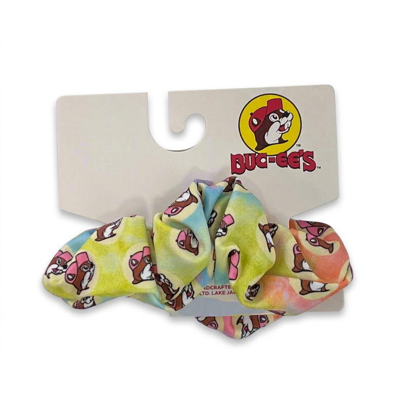 Buc-ee’s Pastel Tie Dye Scrunchie with a pink-cap beaver print in yellow, blue, and peach, on its logo card