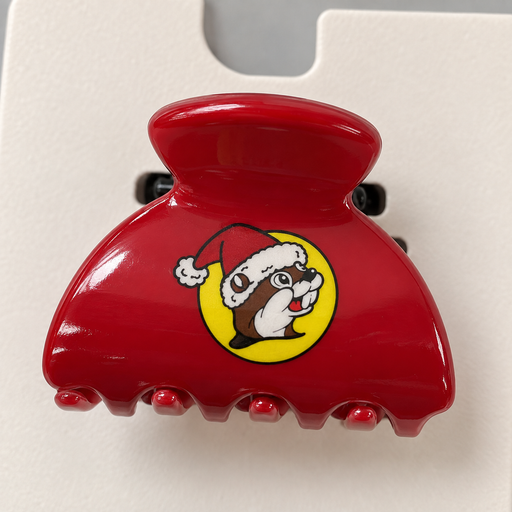 Close-up of a red mini hair claw clip with a Santa Buc-ee logo