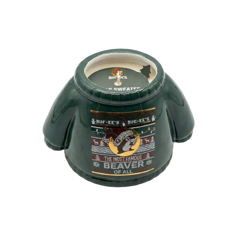 Top view of the Buc-ee’s ugly Christmas sweater candle, showing cream wax, a single wick, and a green branded label inside