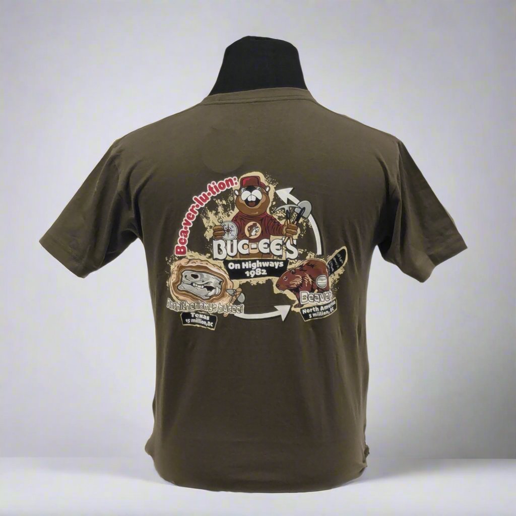 Olive green t-shirt displayed on a black mannequin, showing a detailed graphic on the back illustrating Buc-ee's Beaver Evolution with various designs and text elements