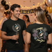 Two people wearing black t-shirts with New Year designs, surrounded by festive decorations and balloons.
