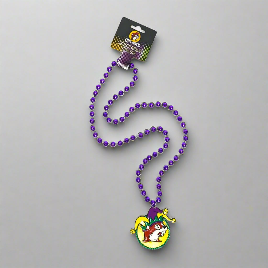 A necklace of purple beads with a Mardi Gras themed pendant featuring a jester character.