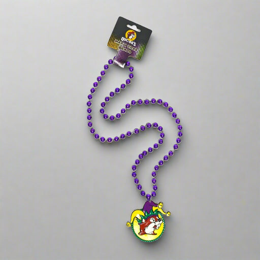 A necklace of purple beads with a Mardi Gras themed pendant featuring a jester character.