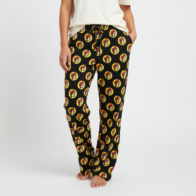 A pair of black pajama pants with a pattern of cartoon raccoon faces in a repeated design.
